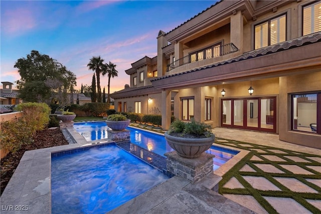 10923 Willow Heights Dr, Las Vegas, NV 89135 - pool at dusk with an in-ground hot tub, an outdoor pool, and a patio