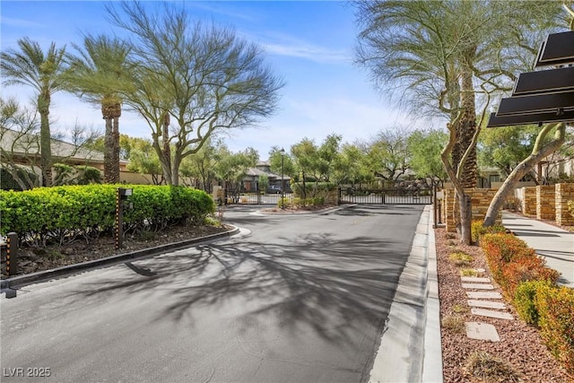 view of road featuring curbs, a gated entry, and a gate