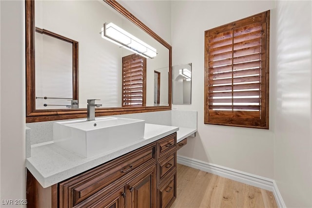 bathroom featuring vanity, baseboards, and wood finished floors