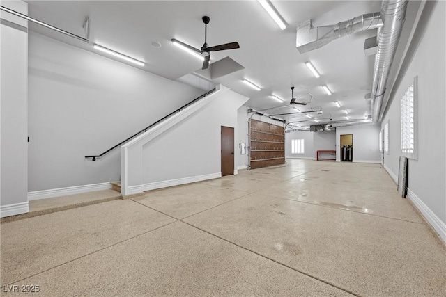 garage featuring baseboards and a ceiling fan