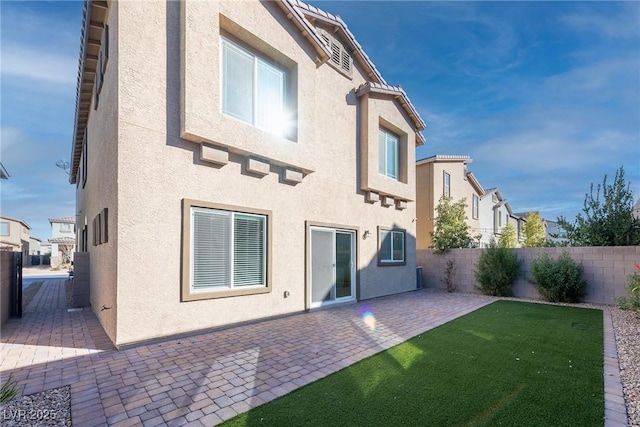 rear view of house with a patio area and a lawn