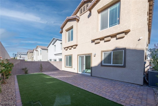 rear view of house with a lawn, a patio area, and central AC unit