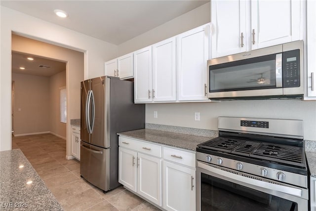 kitchen featuring light stone counters, white cabinets, appliances with stainless steel finishes, and light tile patterned floors