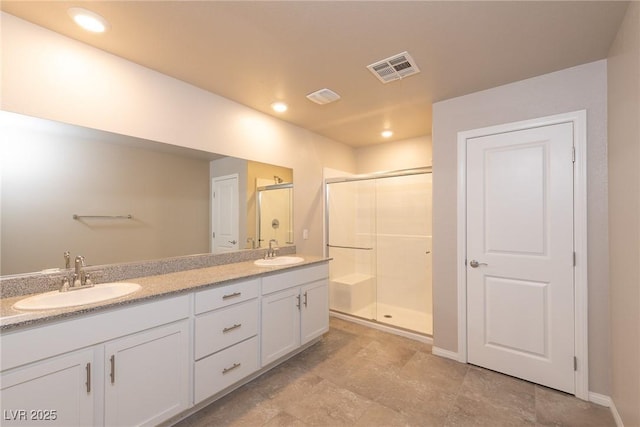 bathroom featuring a shower with shower door and vanity