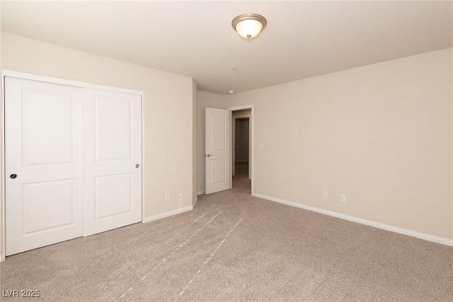 unfurnished bedroom with light colored carpet and a closet