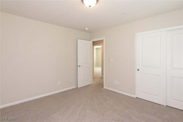 unfurnished bedroom with light colored carpet and a closet