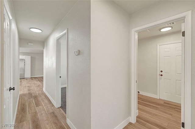 hallway with light hardwood / wood-style flooring