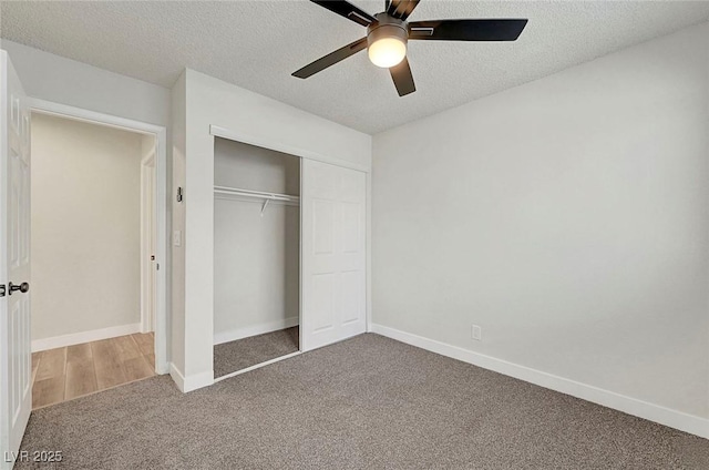 unfurnished bedroom featuring carpet flooring, a textured ceiling, ceiling fan, and a closet