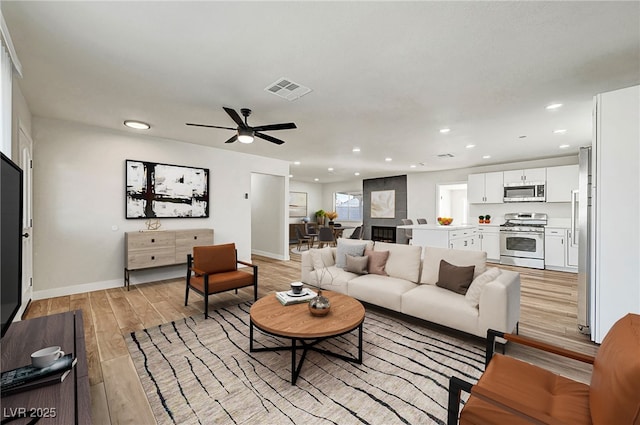 living room featuring ceiling fan and light hardwood / wood-style floors