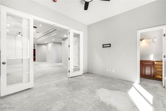 empty room featuring french doors, ceiling fan, and a tray ceiling