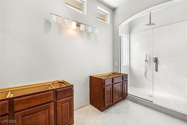 bathroom with a shower with door and concrete floors