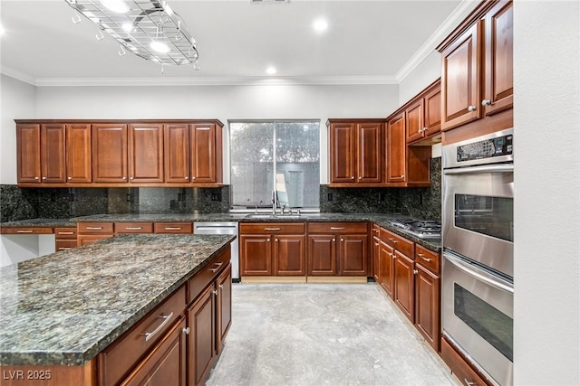 kitchen featuring sink, ornamental molding, dark stone counters, and appliances with stainless steel finishes