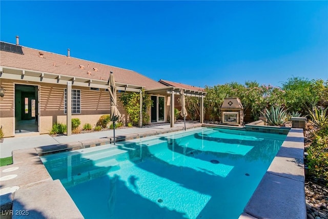 view of pool featuring exterior fireplace and a patio area