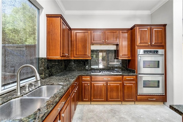 kitchen with sink, crown molding, dark stone counters, and appliances with stainless steel finishes