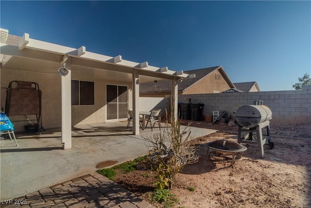 rear view of property with a patio and an outdoor fire pit