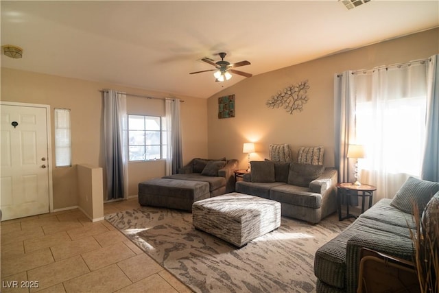 living room featuring ceiling fan, vaulted ceiling, and light tile patterned floors