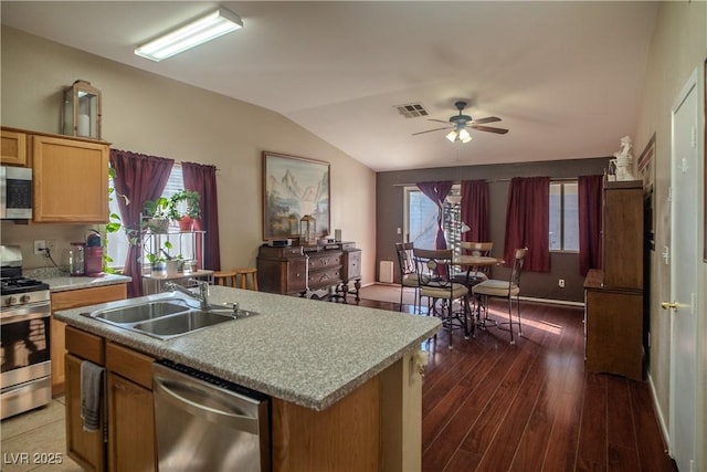 kitchen with stainless steel appliances, sink, ceiling fan, a center island with sink, and dark hardwood / wood-style flooring