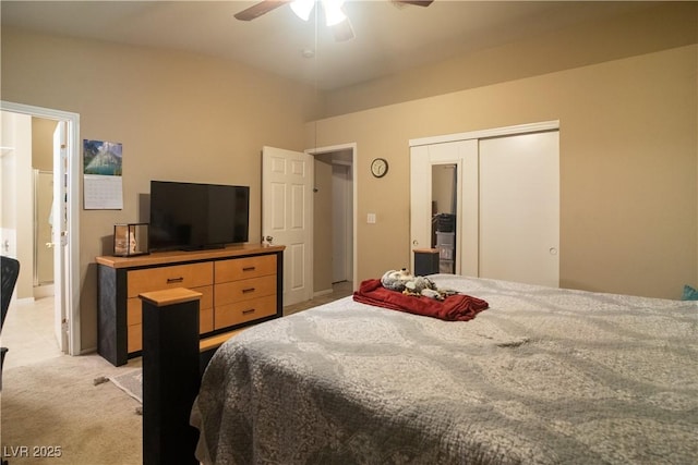 carpeted bedroom with ceiling fan, a closet, and vaulted ceiling