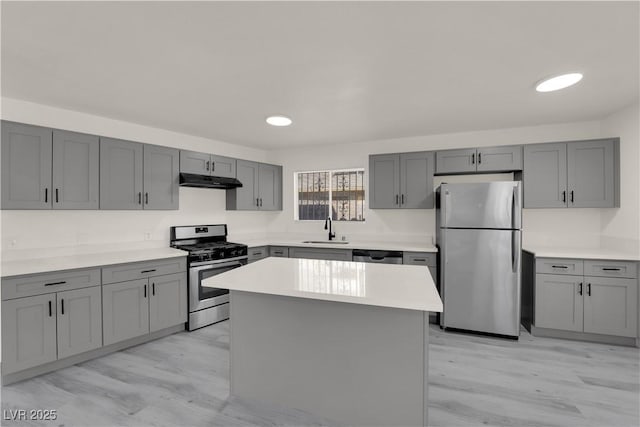 kitchen with stainless steel appliances, sink, a center island, light hardwood / wood-style floors, and gray cabinets