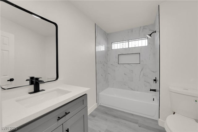 full bathroom with toilet, vanity, tiled shower / bath combo, and hardwood / wood-style floors