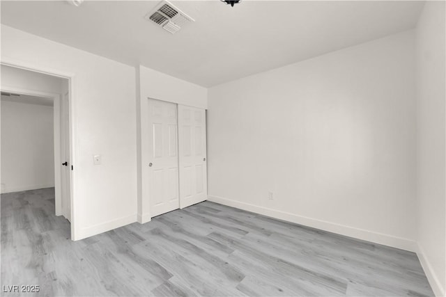 unfurnished bedroom featuring a closet and light wood-type flooring