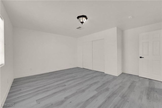 unfurnished room with light wood-type flooring