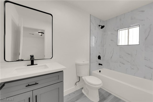 full bathroom with hardwood / wood-style floors, toilet, vanity, and tiled shower / bath