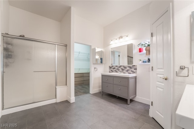 bathroom with vanity, tile patterned flooring, backsplash, and a shower with shower door