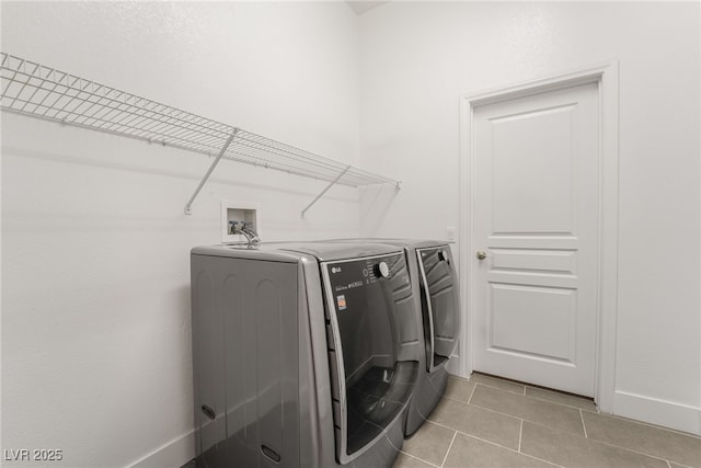 laundry room featuring washing machine and clothes dryer and light tile patterned floors