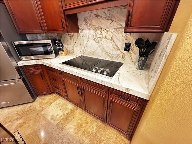 kitchen with stainless steel appliances, backsplash, and light stone counters