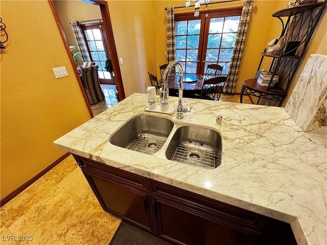 kitchen with light stone counters and sink