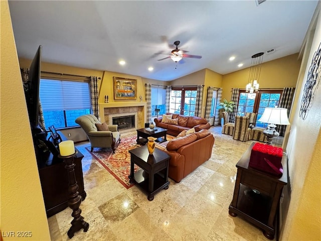 living room featuring vaulted ceiling and ceiling fan with notable chandelier