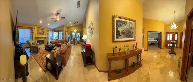 living room with ceiling fan with notable chandelier and high vaulted ceiling