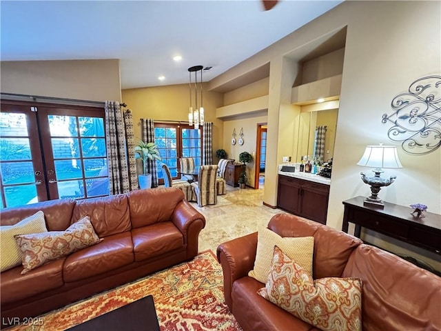 living room featuring an inviting chandelier, french doors, and vaulted ceiling