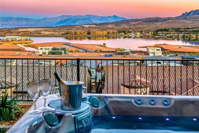 balcony at dusk with a water and mountain view