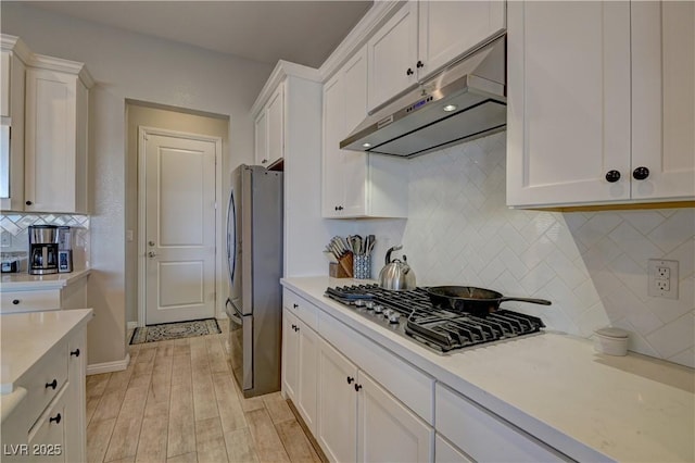 kitchen featuring white cabinetry, backsplash, light hardwood / wood-style flooring, and appliances with stainless steel finishes