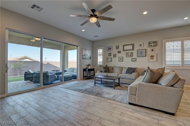 living room with ceiling fan and a wealth of natural light