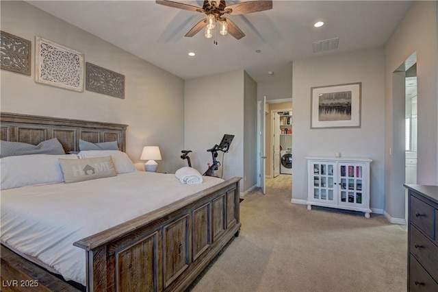 bedroom with ceiling fan, light colored carpet, and washer / dryer