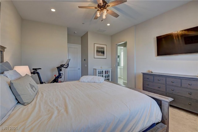 bedroom featuring ensuite bathroom, ceiling fan, and light colored carpet