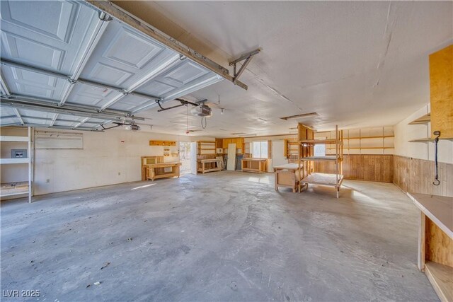 garage featuring a garage door opener and wooden walls