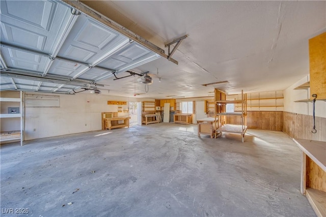 garage featuring a garage door opener and wood walls