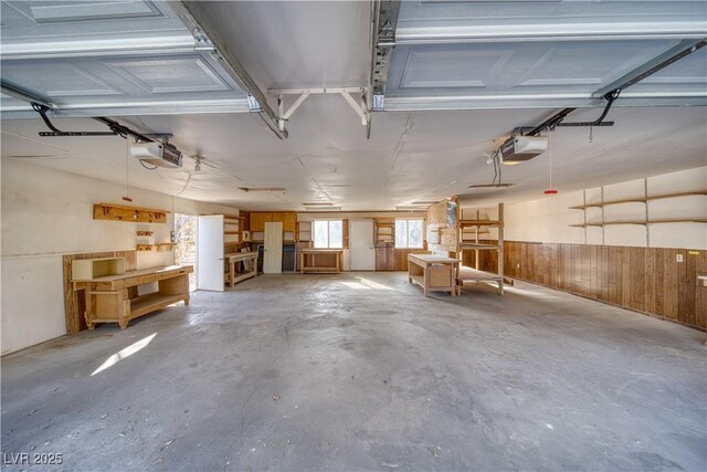 garage with a garage door opener and wood walls