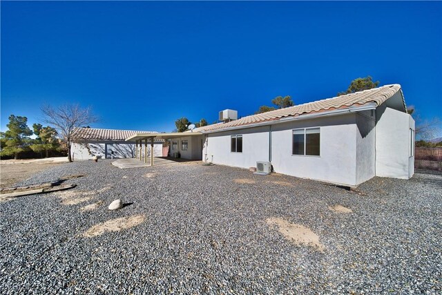 rear view of house featuring ac unit and central air condition unit