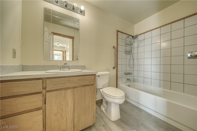 full bathroom with vanity, toilet, tiled shower / bath combo, and hardwood / wood-style floors