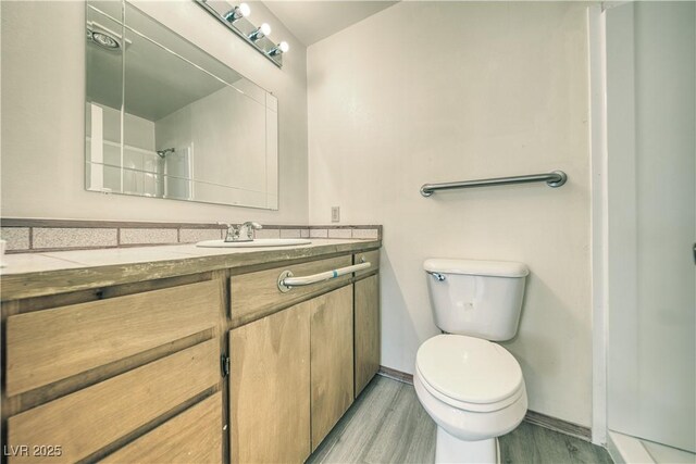 bathroom with toilet, walk in shower, wood-type flooring, and vanity