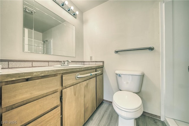 bathroom with hardwood / wood-style flooring, vanity, toilet, and a shower