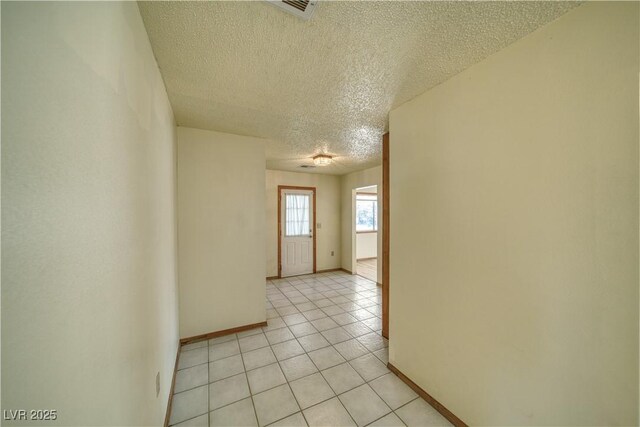 tiled spare room with a textured ceiling