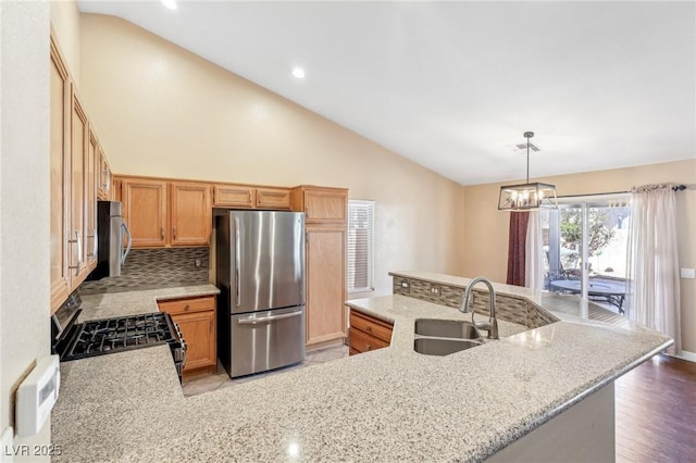 kitchen featuring sink, decorative light fixtures, light stone counters, tasteful backsplash, and appliances with stainless steel finishes