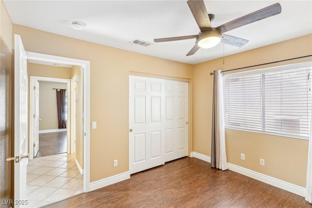 unfurnished bedroom featuring a closet, ceiling fan, and light hardwood / wood-style flooring