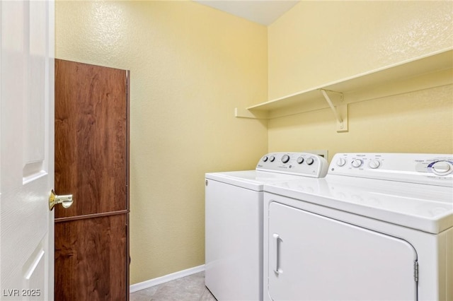 laundry room featuring washer and clothes dryer and light tile patterned floors